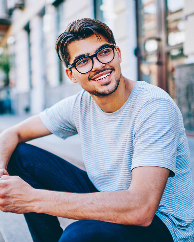 Carefree male in stylish spectacles laughing and looking away
